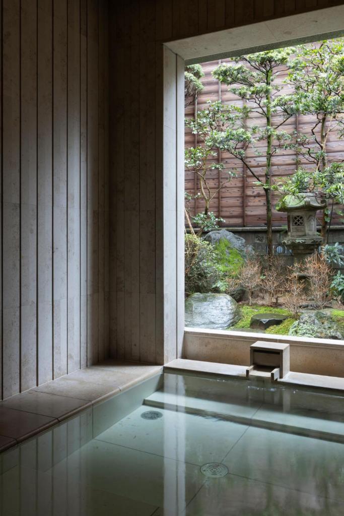 une piscine avec une fenêtre dans une maison dans l'établissement Mikuniya, à Toyooka