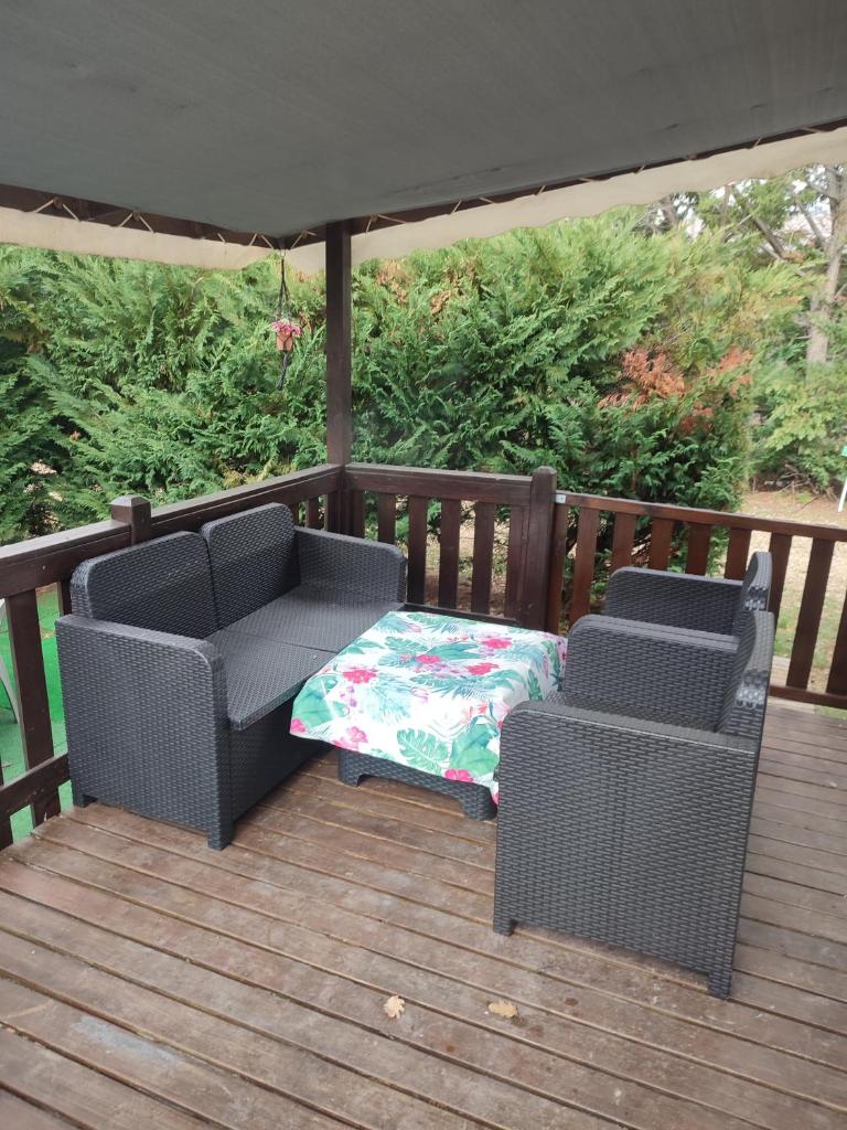 2 chaises en osier et une table sur une terrasse dans l'établissement Mobil home a ste croix du verdon camping 3, à Sainte-Croix-de-Verdon