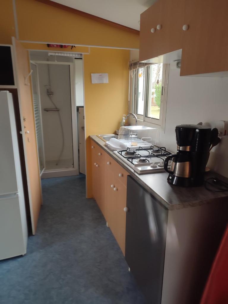 une cuisine avec une cuisinière et un évier dans l'établissement Mobil home a ste croix du verdon camping 3, à Sainte-Croix-de-Verdon