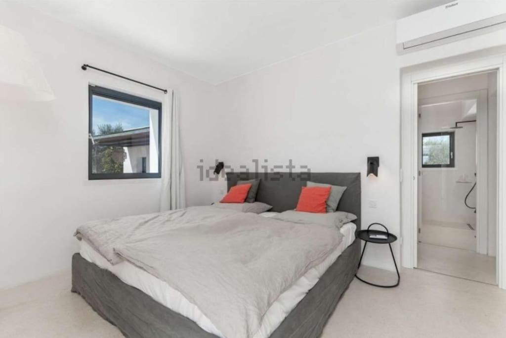 - une chambre blanche avec un grand lit et des oreillers orange dans l'établissement Villa Monika - Luxury Trulli Resort, à Locorotondo 73 autres photos