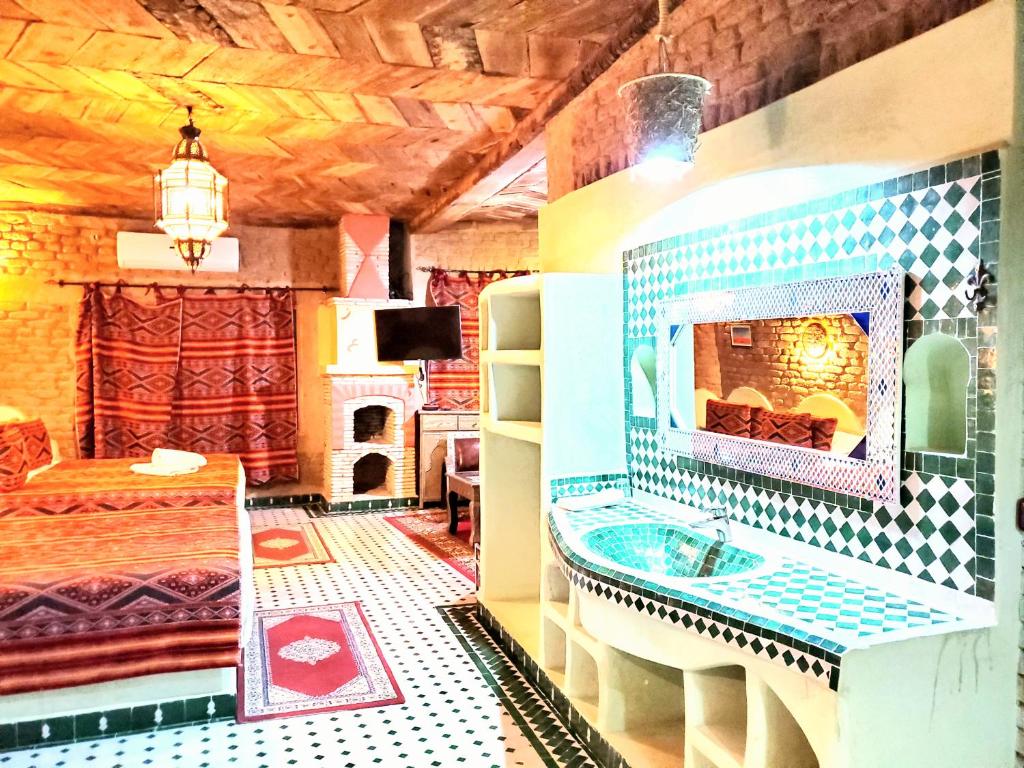 La salle de bains est pourvue d'un lavabo et d'une cheminée. dans l'établissement Riad Ksar Merzouga, à Merzouga