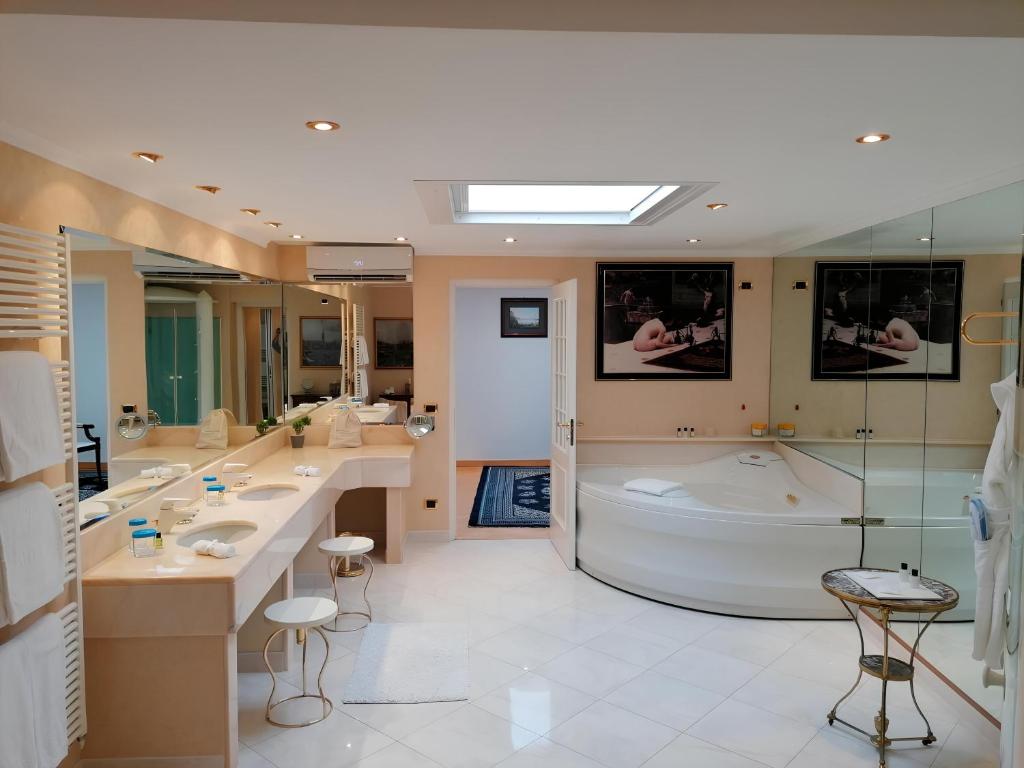 une salle de bain avec deux lavabos et une baignoire dans l'établissement Grand Hotel Del Mare Resort & Spa, à Bordighera