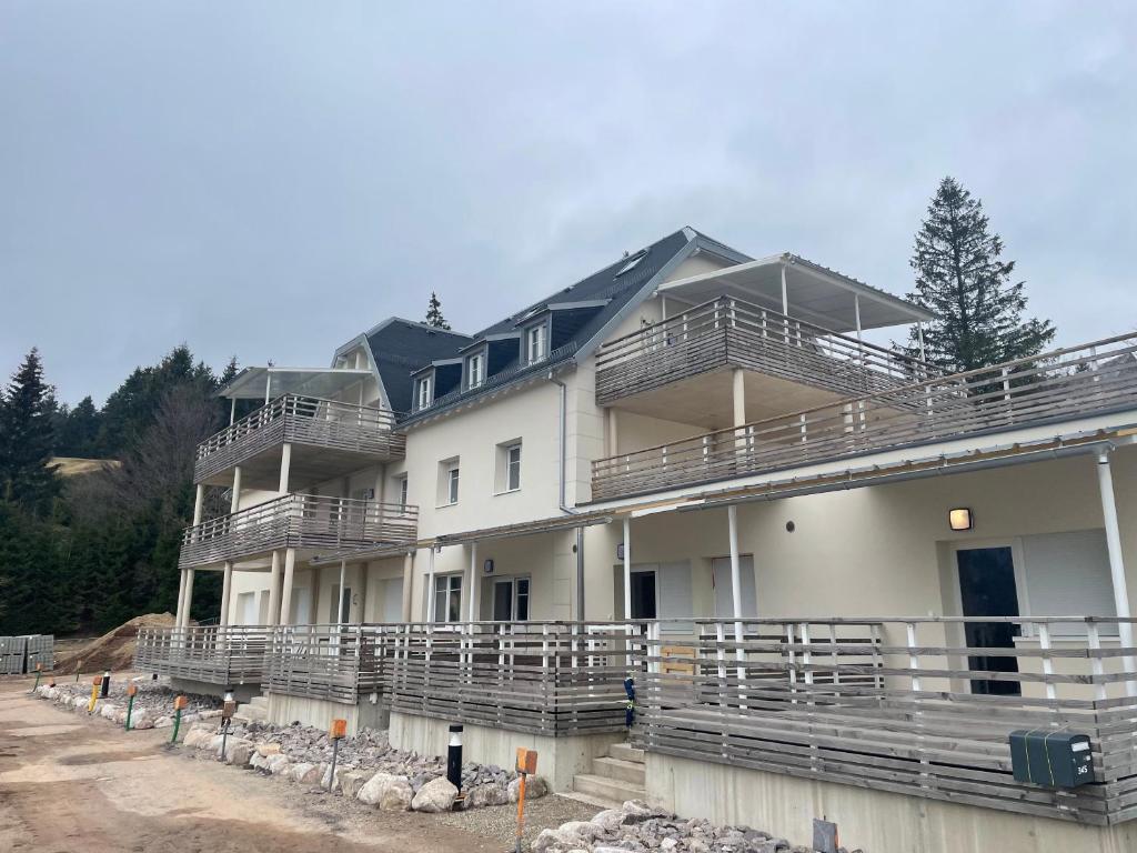 - un grand bâtiment blanc avec balcon dans l'établissement Appartement - Au cœur du Lac Blanc, à Orbey