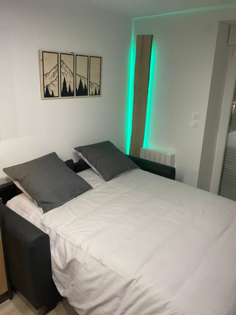 une chambre avec un grand lit avec des draps blancs dans l'établissement Appartement - Au cœur du Lac Blanc, à Orbey