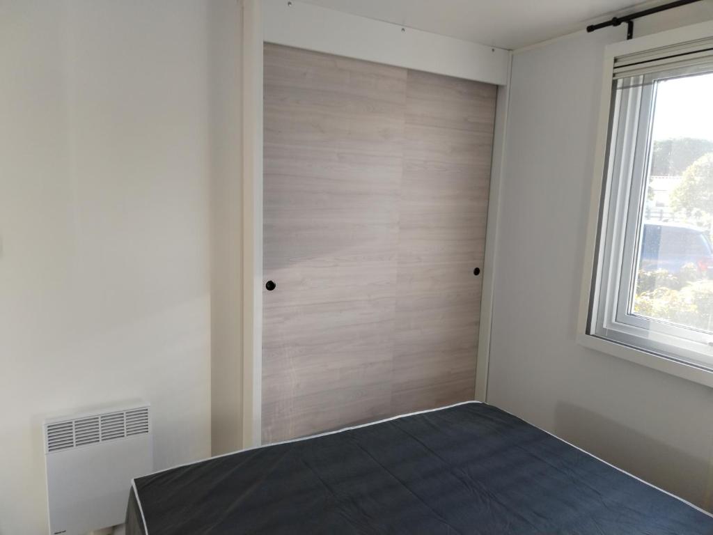 une chambre avec un lit et une fenêtre dans l'établissement Camping Le Lac des Rêves Lattes, à Pérols 2 autres photos