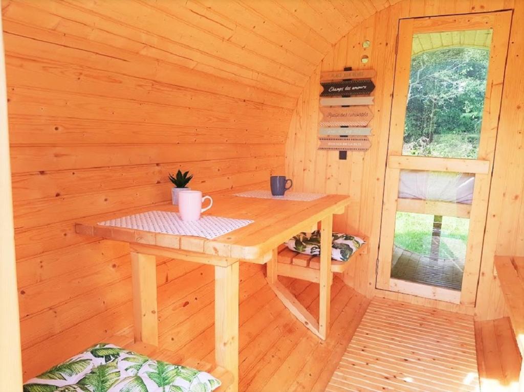 Cette chambre en bois comprend une table dans une cabine. dans l'établissement Tonneau bulle insolite, vue sur vignoble, à Pouldergat