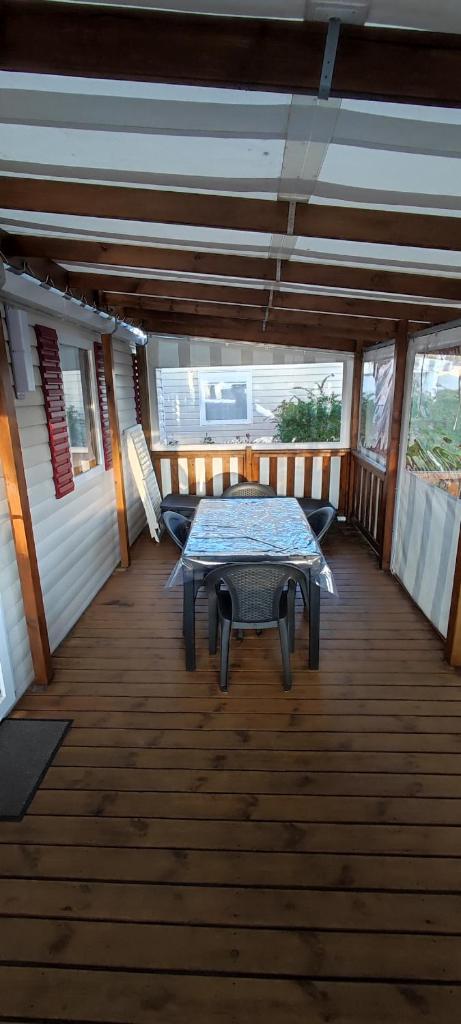 une terrasse en bois avec une table. dans l'établissement Au bonheur des Landes, à Gastes