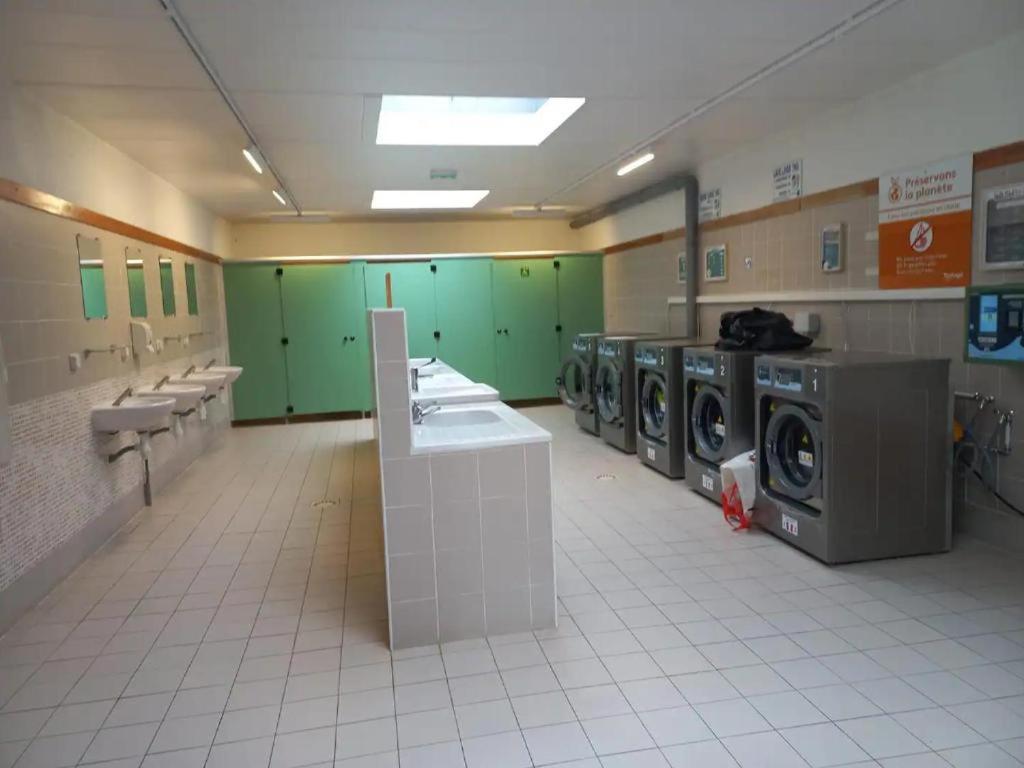 une salle de bains avec lave-linge et lavabos dans une laverie dans l'établissement Mobil-House 2 chambres Saint-Chéron, à Saint-Chéron