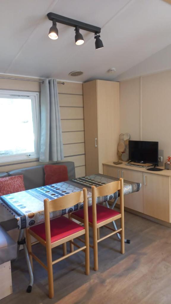 une pièce avec une table et des chaises et une cuisine dans l'établissement Mobil-House 2 chambres Saint-Chéron, à Saint-Chéron