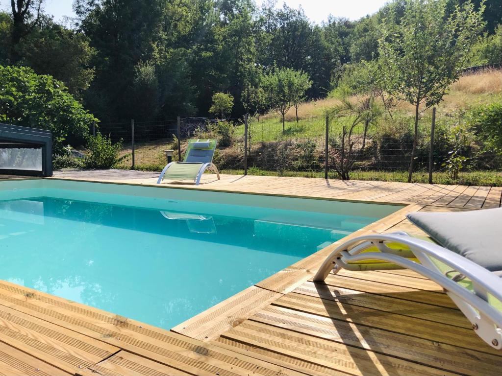 - une piscine avec une terrasse et une chaise dans l'établissement Petite Fugue, à Cransac 20 autres photos