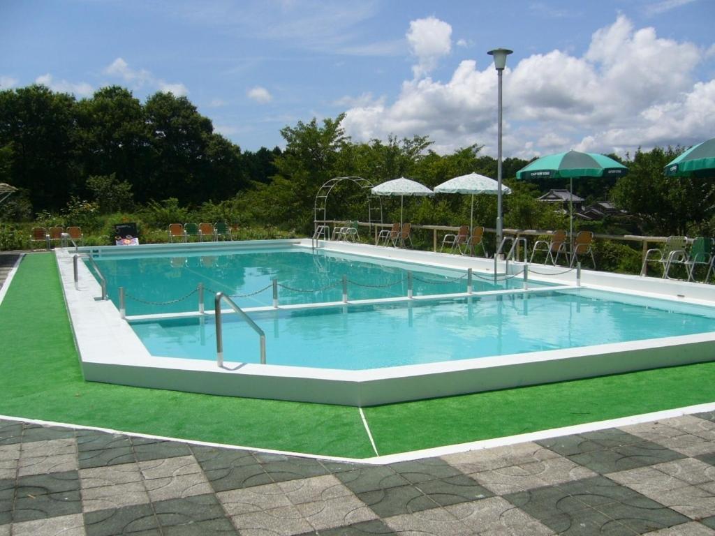 une grande piscine d'eau bleue et d'herbe verte dans l'établissement Shorenji Lake Hotel, à Nabari