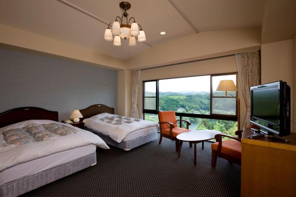 une chambre d'hôtel avec deux lits et une télévision à écran plat dans l'établissement Shorenji Lake Hotel, à Nabari