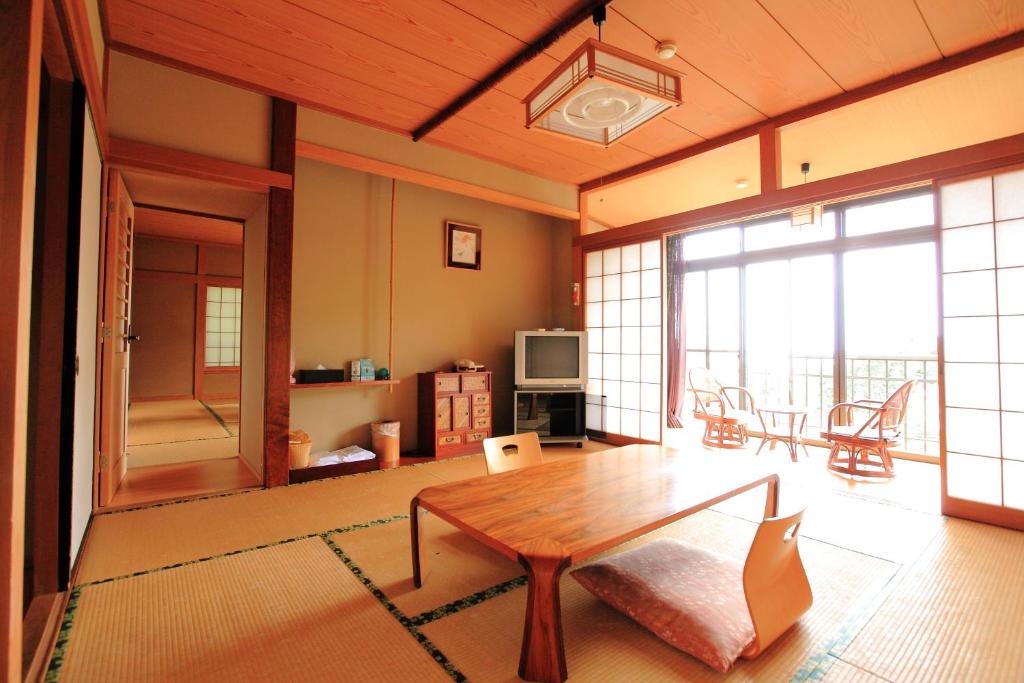 Il comprend un grand salon avec une table et une télévision. dans l'établissement Kokoronodoka, à Kawazu