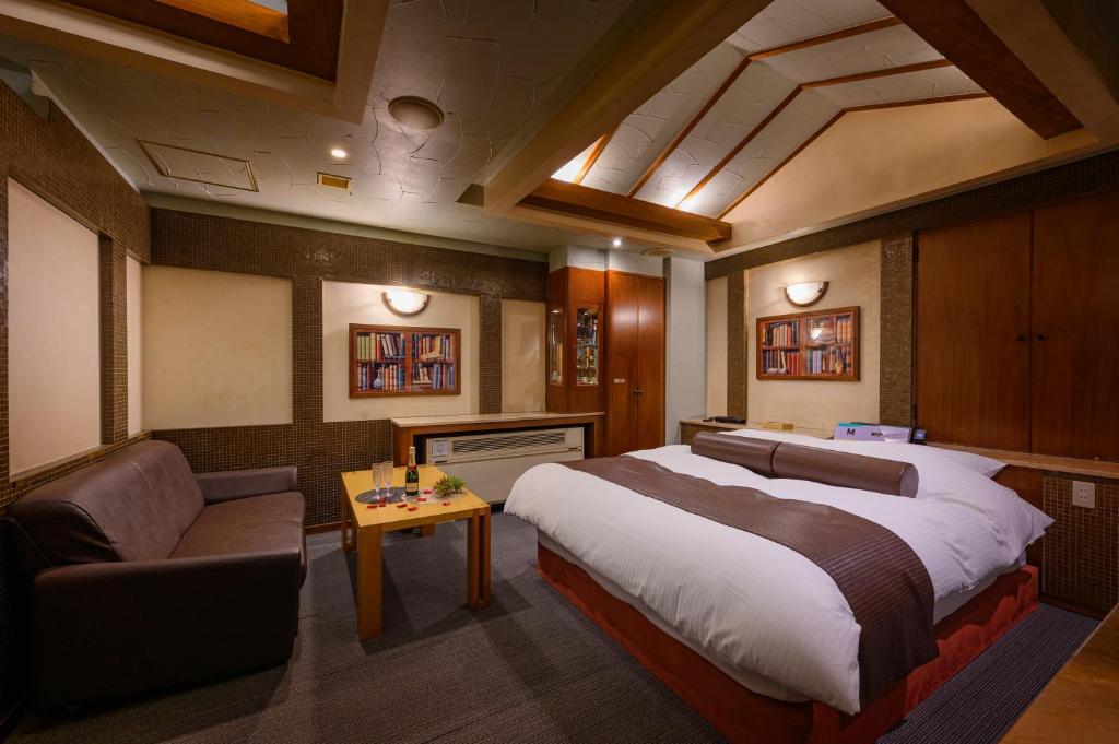 une chambre avec un grand lit et un canapé dans l'établissement Water Hotel Mw (Love Hotel), à Saitama
