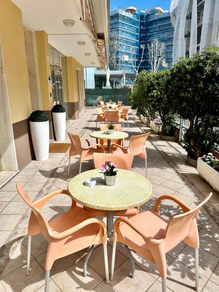 une rangée de tables et de chaises sur une terrasse dans l'établissement Hotel Enna Rimini, à Rimini 46 autres photos