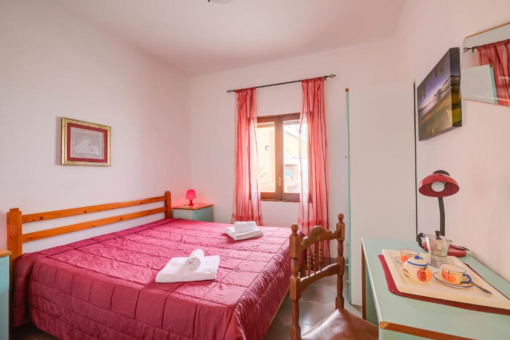 une chambre avec un lit avec un couvre-lit rouge dans l'établissement Villa Oasi al mare near the sea with pool - Happy Rentals, à Melendugno