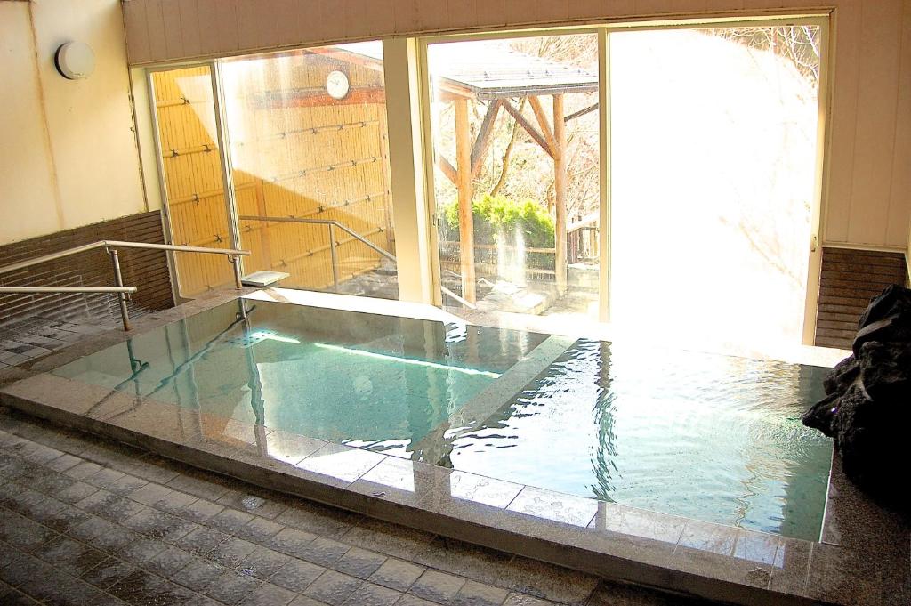 - une piscine dans une chambre avec fenêtre dans l'établissement Sawatari Onsen Miyataya Ryokan, à Nakanojo