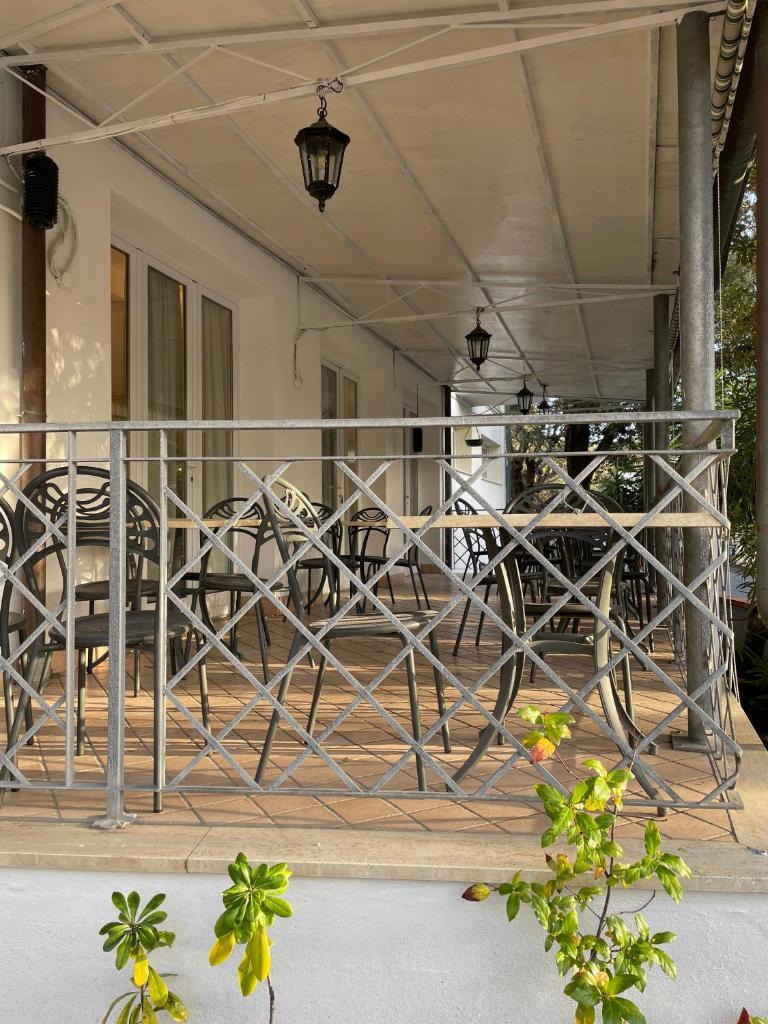 une balustrade en métal sur une terrasse couverte avec des tables et des chaises dans l'établissement Hotel l'Etrusco - San Vincenzo, à San Vincenzo