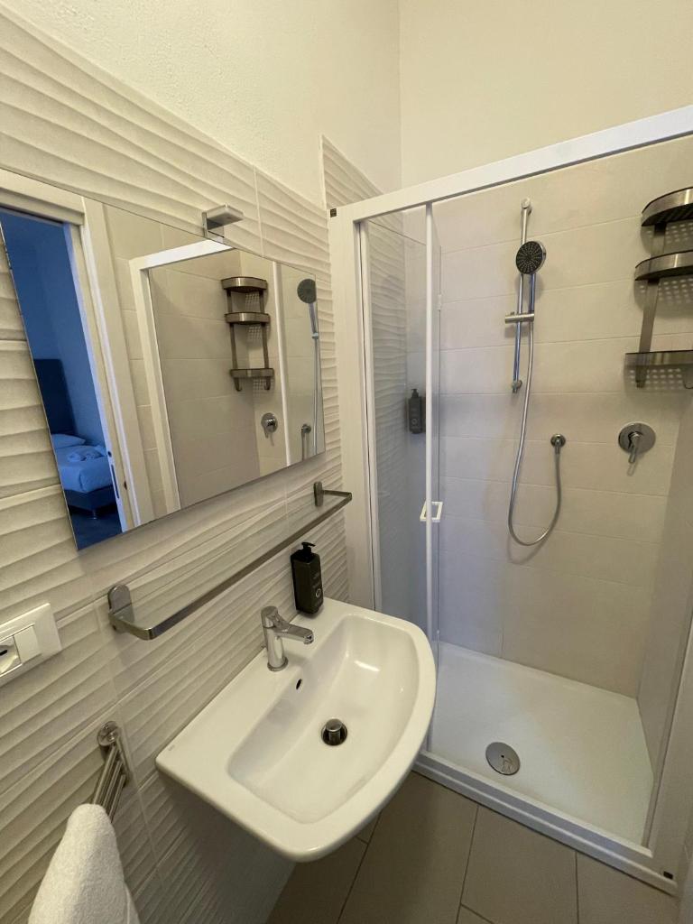 une salle de bain blanche avec lavabo et douche dans l'établissement Hotel l'Etrusco - San Vincenzo, à San Vincenzo 32 autres photos