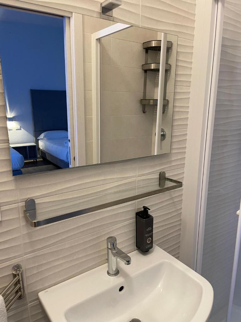 une salle de bain avec un lavabo et un miroir dans l'établissement Hotel l'Etrusco - San Vincenzo, à San Vincenzo