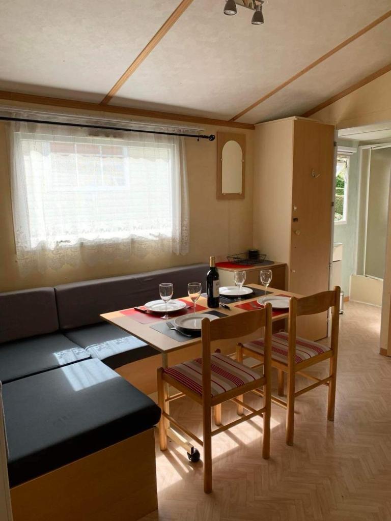 un salon avec une table et un canapé dans l'établissement Mobilhome, à Castillonnès