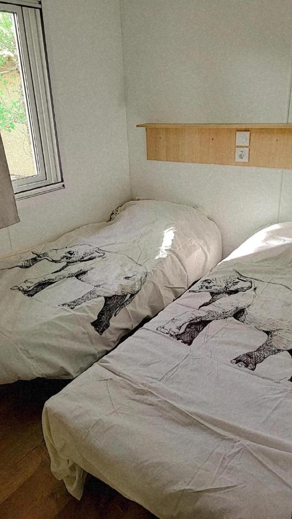 deux lits côte à côte dans une chambre dans l'établissement Superbe mobile home neuf - Mazet 71 - Camping la Carabasse, à Vias