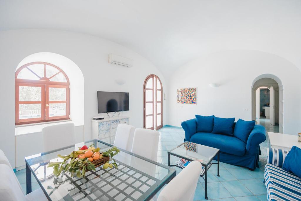 un salon avec un canapé bleu et une table dans l'établissement Villa Capri by MyVillaCollection, à Capri