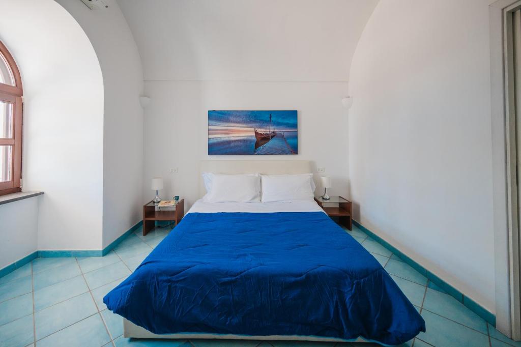 une chambre avec un lit avec une couverture bleue dans l'établissement Villa Capri by MyVillaCollection, à Capri