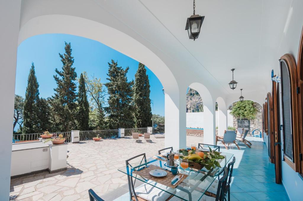 d'une terrasse avec une table, des chaises et une voûte. dans l'établissement Villa Capri by MyVillaCollection, à Capri 61 autres photos
