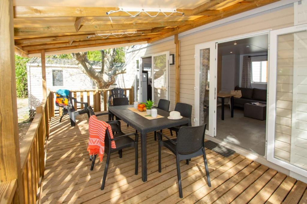 un patio avec une table et des chaises sur une terrasse dans l'établissement Camping Les Pêcheurs - Maeva, à Roquebrune-sur Argens