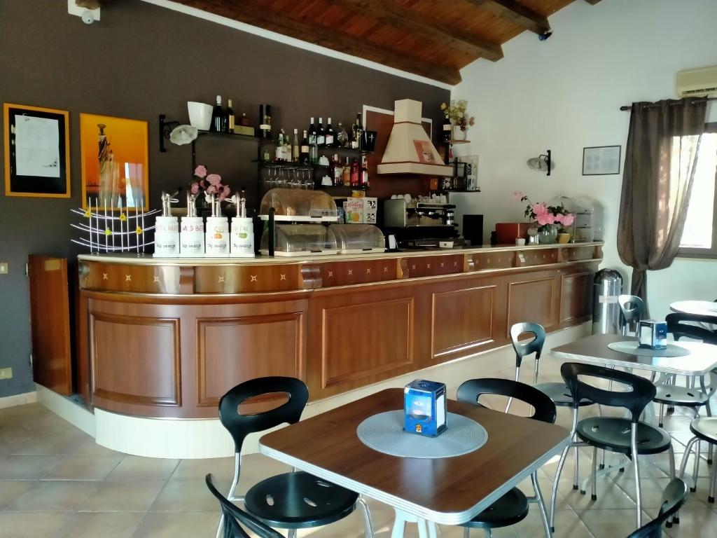 un restaurant avec des tables et des chaises devant un comptoir dans l'établissement Hotel Grotticelli, à Scopello