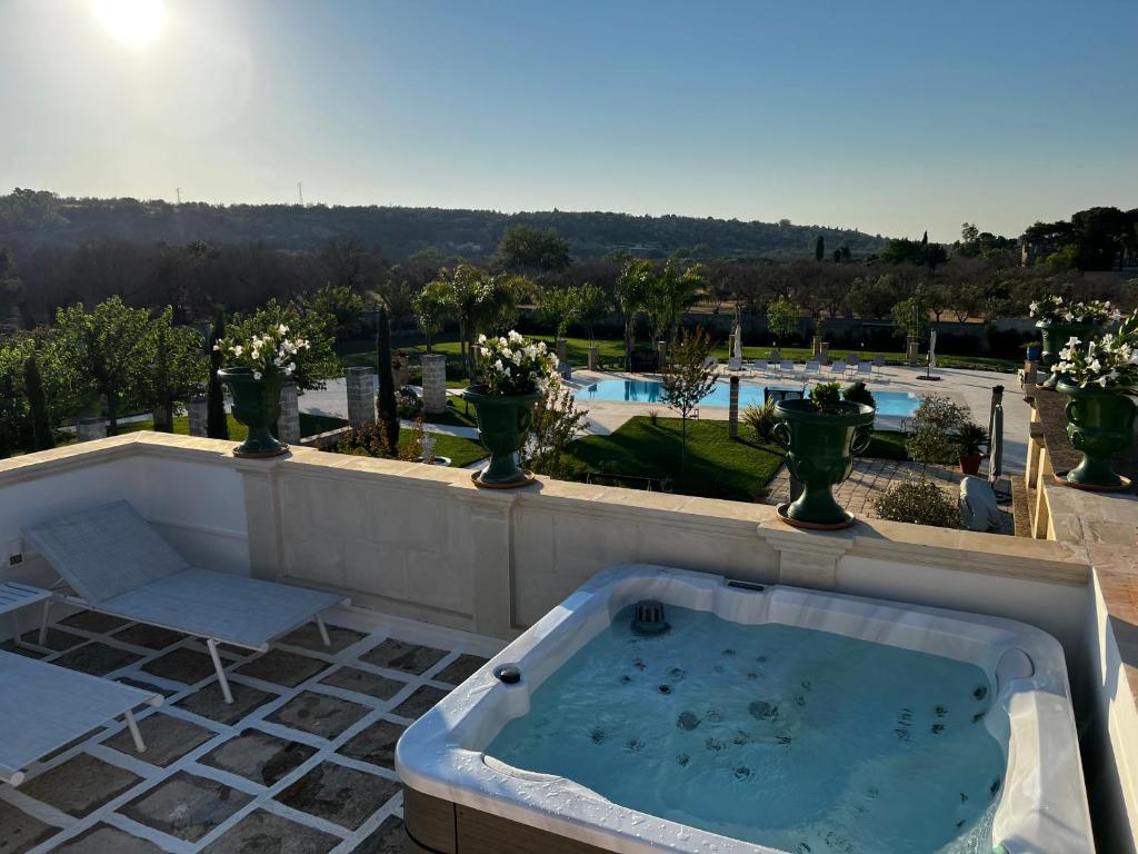 un bain à remous sur une terrasse avec vases dans l'établissement Villa Anna - Suites & Events, à Specchia