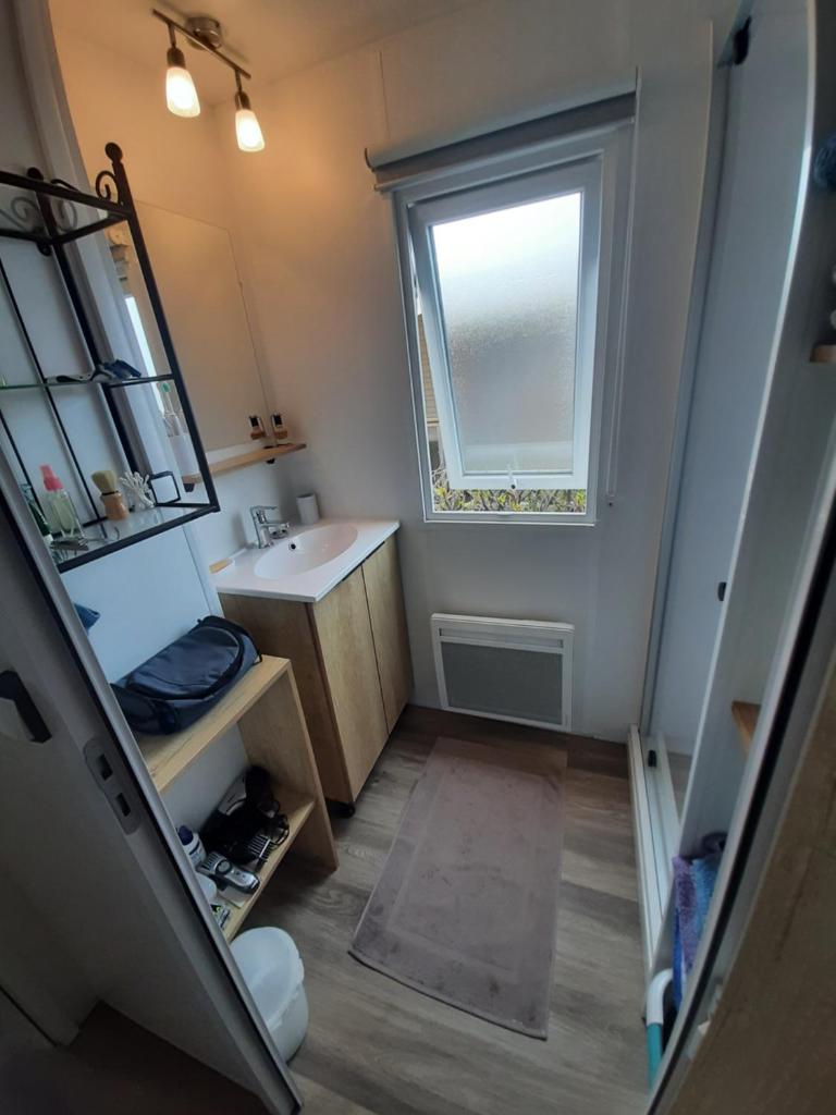une petite salle de bain avec un lavabo et une fenêtre dans l'établissement SERENITY 565 au Lac Des Rêves-camping 4 étoiles-mobil home 3ch-6pl-clim-sdb- wc séparé-au calme, belle vue sur le lac, sans vis à vis, à Lattes