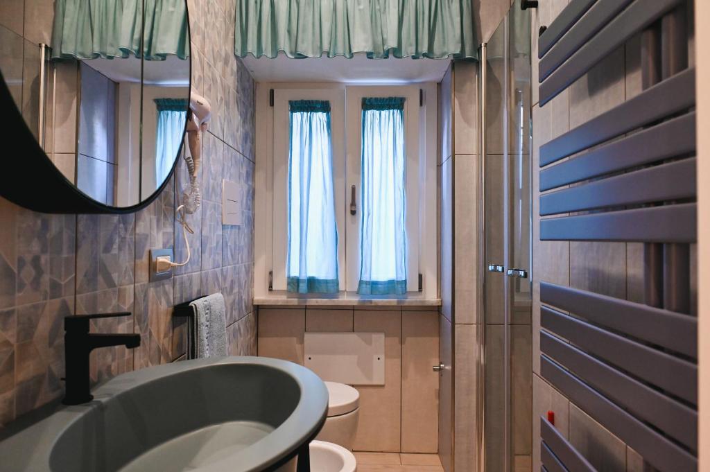 une salle de bain avec un lavabo, des toilettes et un miroir dans l'établissement Domus Marina - Baltico Apartment, à Mondragone