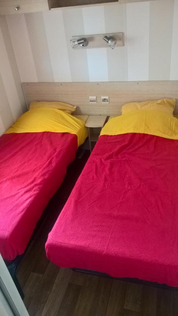 deux lits côte à côte dans une pièce dans l'établissement location mobile-home IRM super octavia 36m2, à La Tranche-sur-Mer 20 autres photos