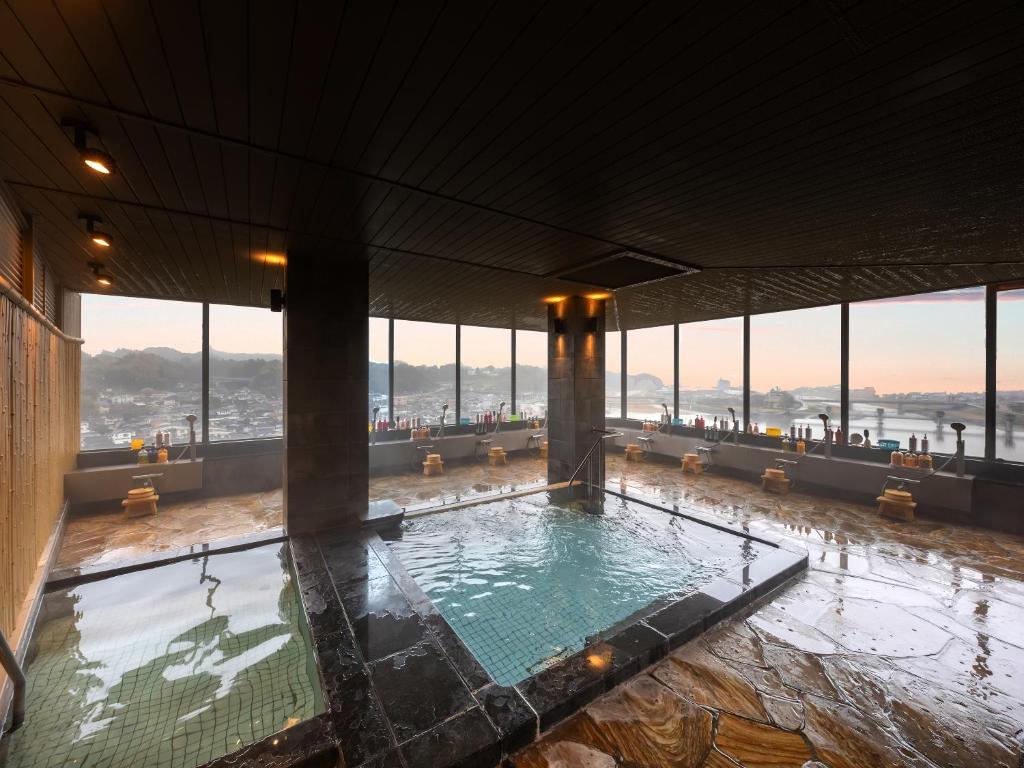 une piscine dans un immeuble avec de grandes fenêtres dans l'établissement Mikuma Hotel, à Hita 37 autres photos