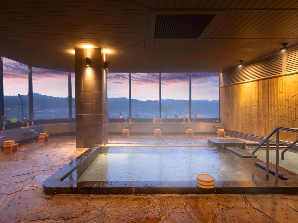 - une grande piscine dans un bâtiment doté de fenêtres dans l'établissement Mikuma Hotel, à Hita