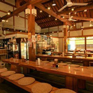 - un restaurant avec des tables et des tabourets en bois dans une chambre dans l'établissement Watarase Onsen Hotel Yamayuri, à Hongu