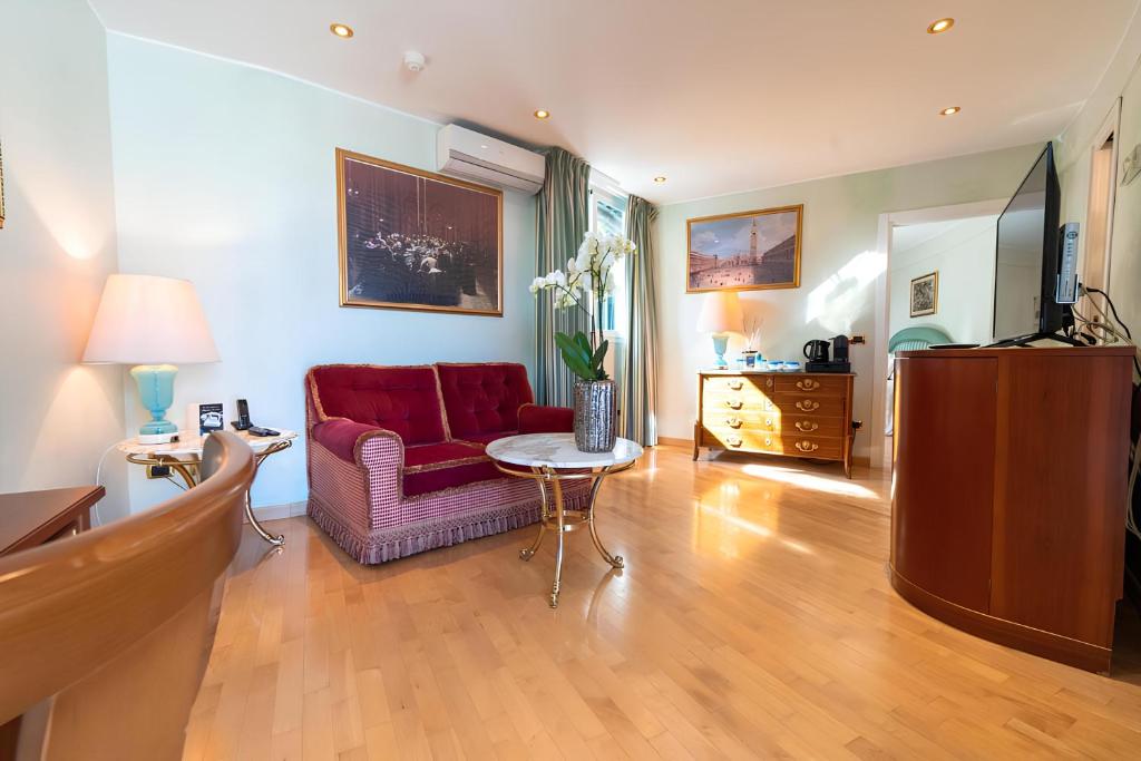 un salon avec une chaise rouge et une table dans l'établissement Grand Hotel Del Mare Resort & Spa, à Bordighera