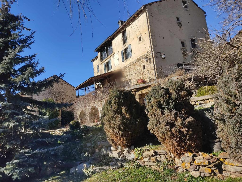un vieux bâtiment sur le côté d'une colline dans l'établissement Le château brangoly, à Enveitg