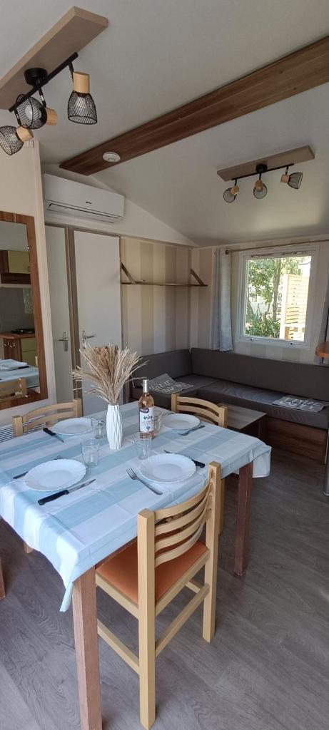 une salle à manger avec une table et des chaises bleues dans l'établissement Mobil home 6 personnes confort Océan climatisé camping avec piscine Agde, à Agde