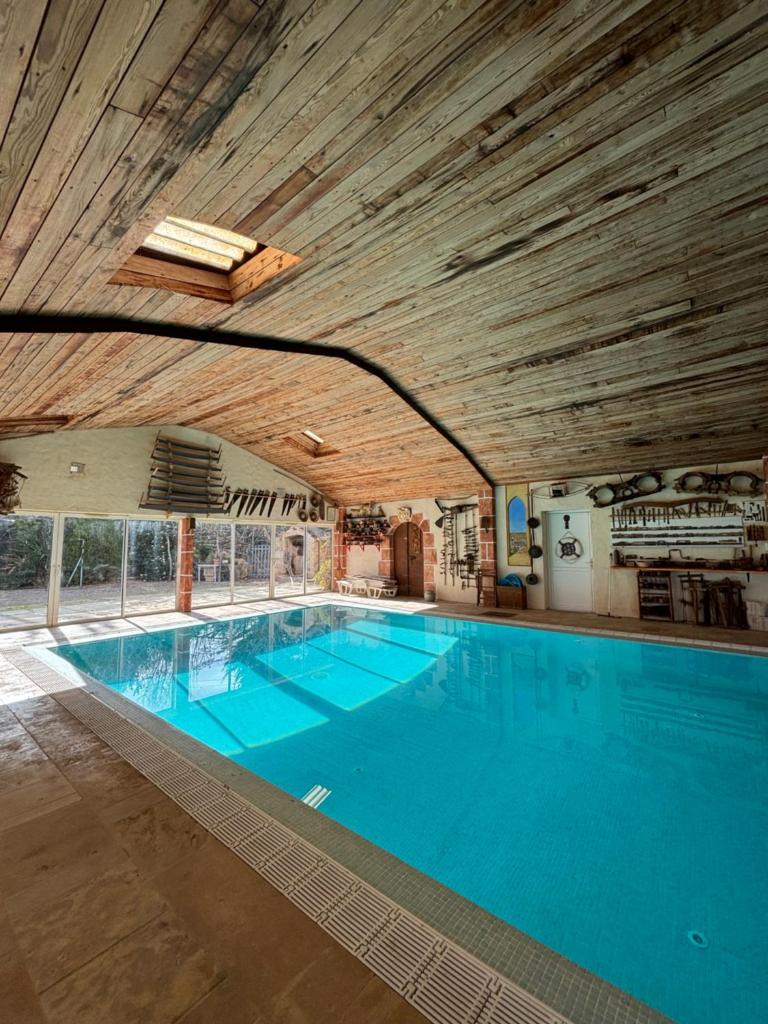 une grande piscine avec de l'eau bleue dans un immeuble dans l'établissement Gite LA FONTAINE, à Peyriac-de-Mer