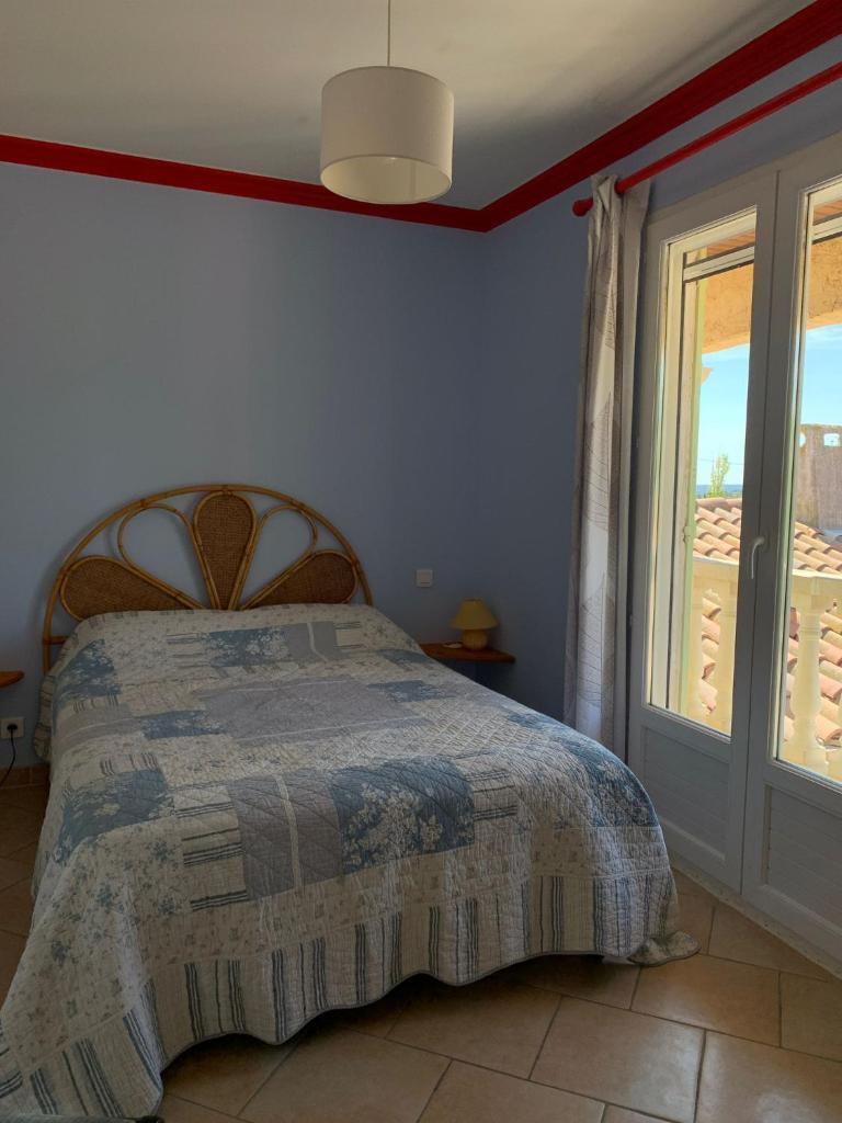 une chambre avec un lit et une grande fenêtre dans l'établissement Gite LA FONTAINE, à Peyriac-de-Mer