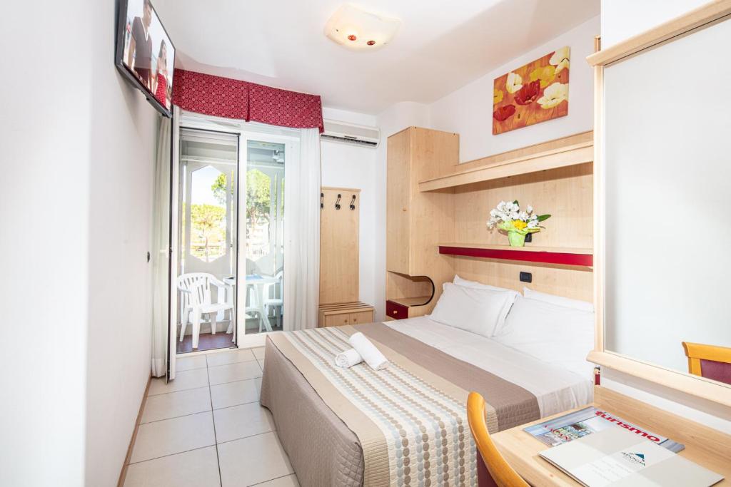 une chambre d'hôtel avec un lit et une table dans l'établissement Hotel Regina, à Lignano Sabbiadoro