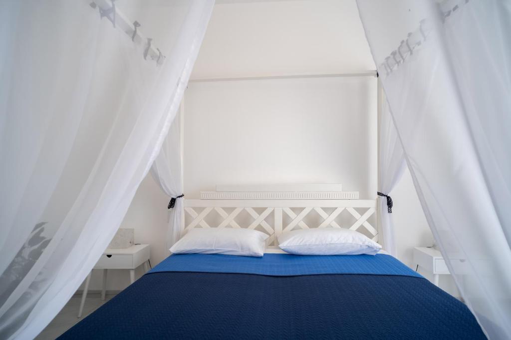 - une chambre avec un lit bleu et des rideaux blancs dans l'établissement holiday inn endless summer, à Alcamo 52 autres photos