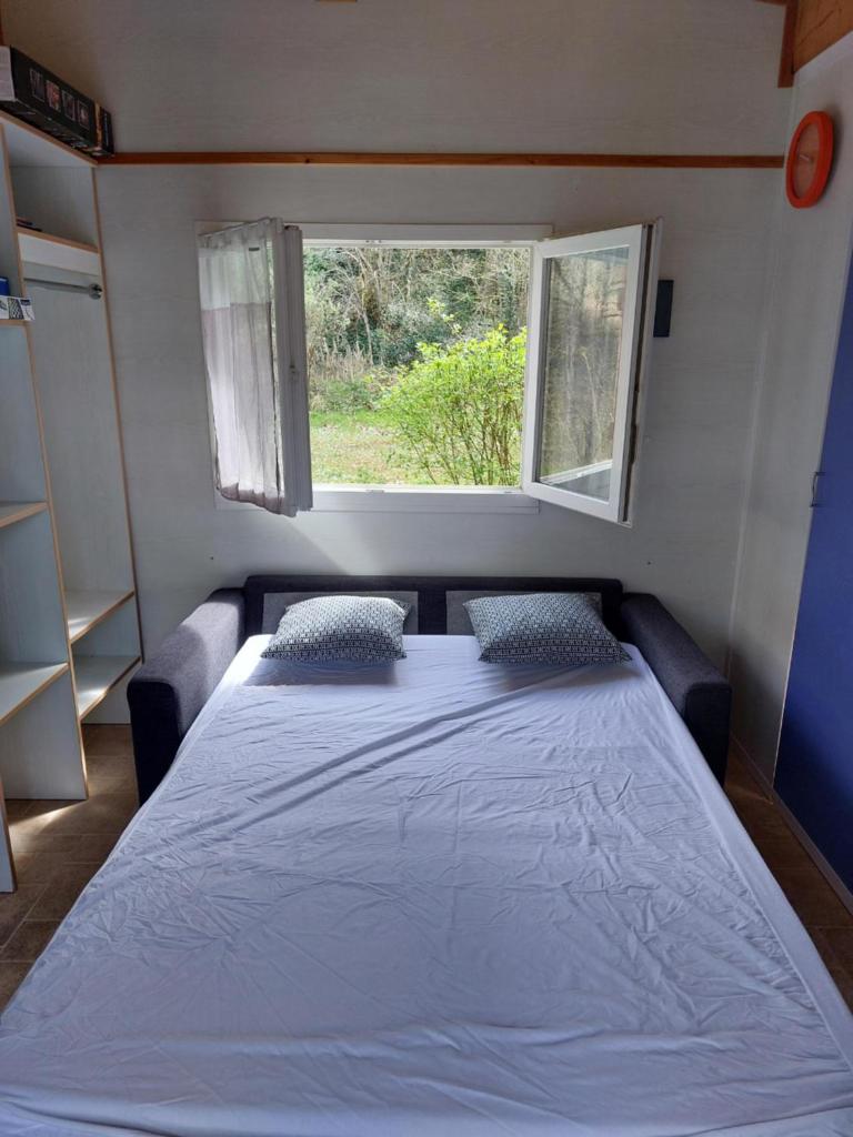 un lit dans une petite pièce avec une fenêtre dans l'établissement Chalet 6 places, à Saint-Thomas-en-Royans