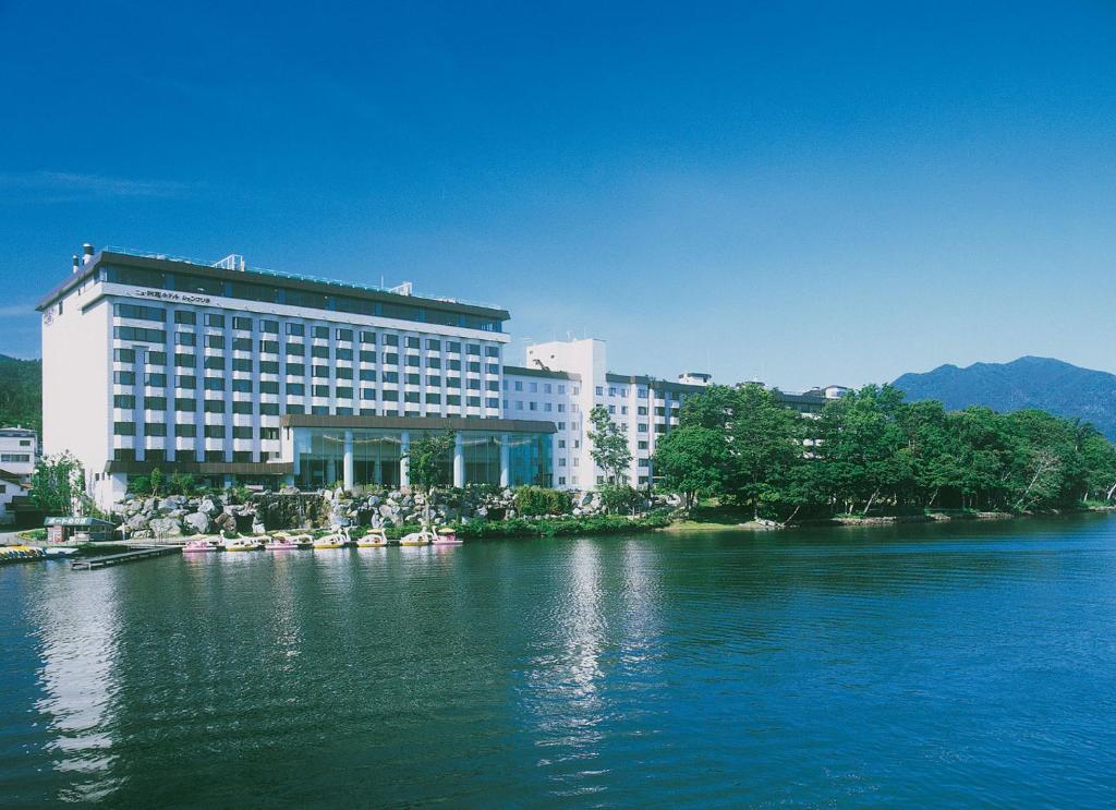un grand bâtiment à côté d'une grande étendue d'eau dans l'établissement New Akan Hotel, à Akankohan
