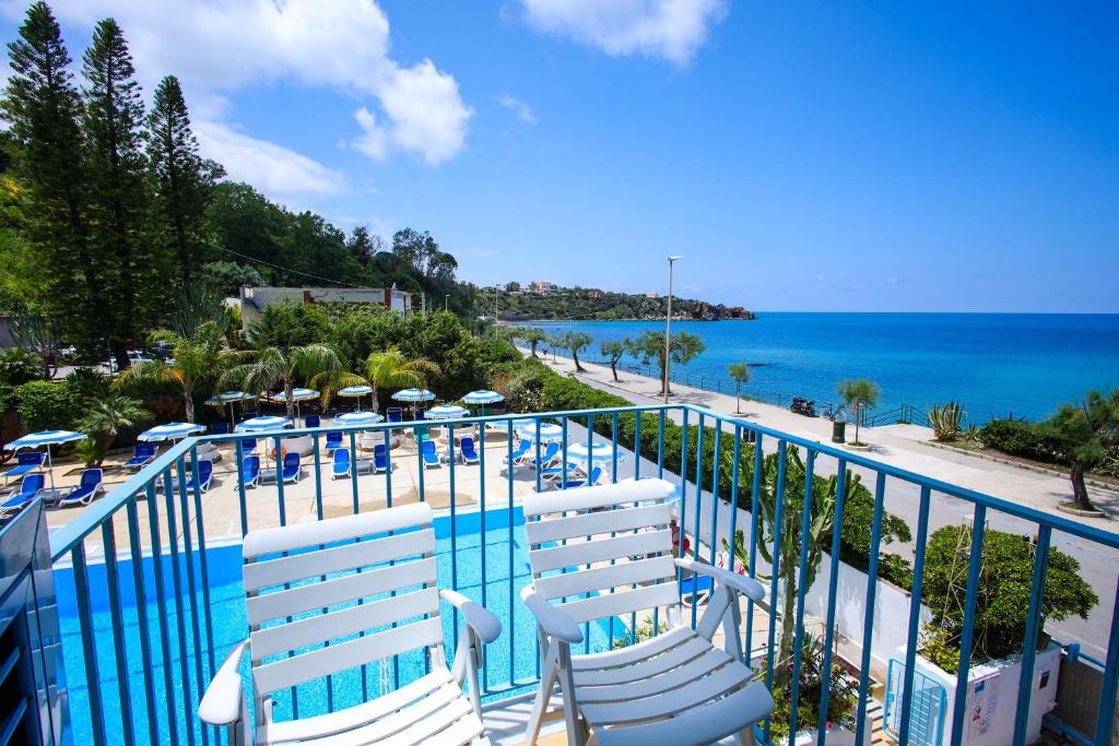 - une vue sur la piscine avec des chaises et l'océan dans l'établissement Hotel Tourist, à Cefalù