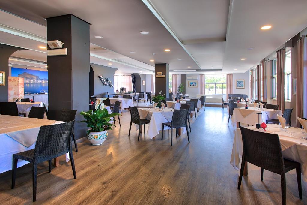 une salle à manger avec des tables et des chaises dans un restaurant dans l'établissement Hotel Tourist, à Cefalù