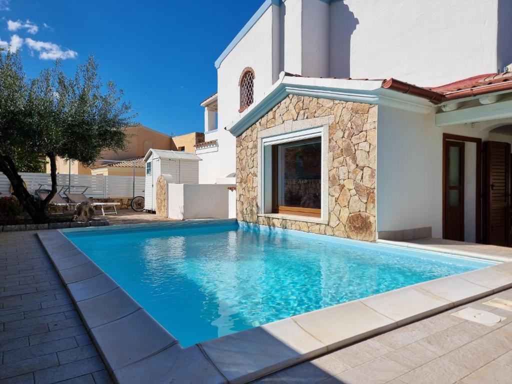 une piscine devant une maison dans l'établissement Res S'Abbaida C1 con Piscina Privata, à Tanaunella